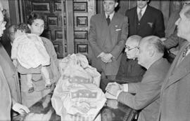 Entrega de bolsas norteamericanas con productos alimenticios en el Gobierno Civil. Enero de 1954....