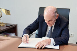 Miquel Roca i Junyent firma el Libro de Honor de la Universidad de Málaga. Paraninfo. Diciembre de 2024